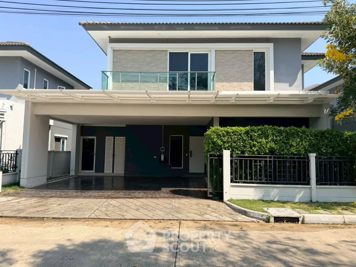 Modern two-story house with spacious driveway and balcony in a serene neighborhood.