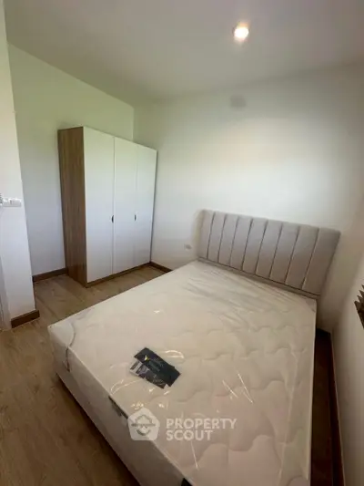 Modern bedroom with new mattress and sleek wardrobe in minimalist design.