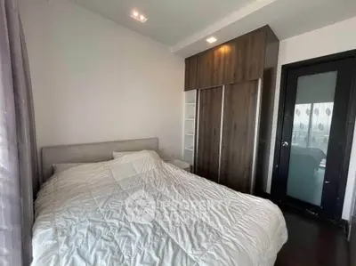 Cozy bedroom with modern wardrobe and large window for natural light.