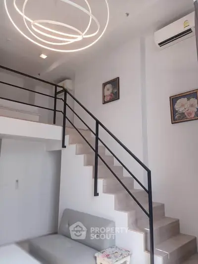 Modern loft-style living room with elegant staircase and chic lighting