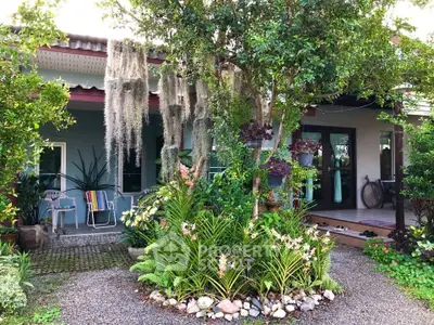 Charming house exterior with lush garden and inviting porch, perfect for nature lovers.