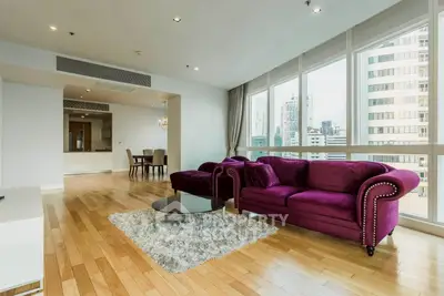 Spacious living room with purple sofa and city view in modern apartment