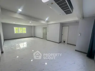 Spacious modern living room with sleek flooring and ample natural light