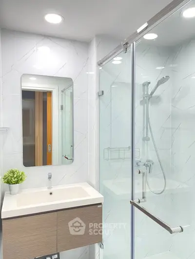 Modern bathroom with sleek shower and stylish vanity in contemporary home.