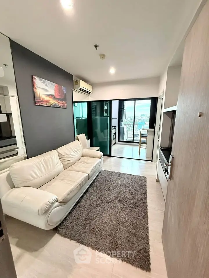 Modern living room with white sofa, stylish decor, and open balcony view in a chic apartment.