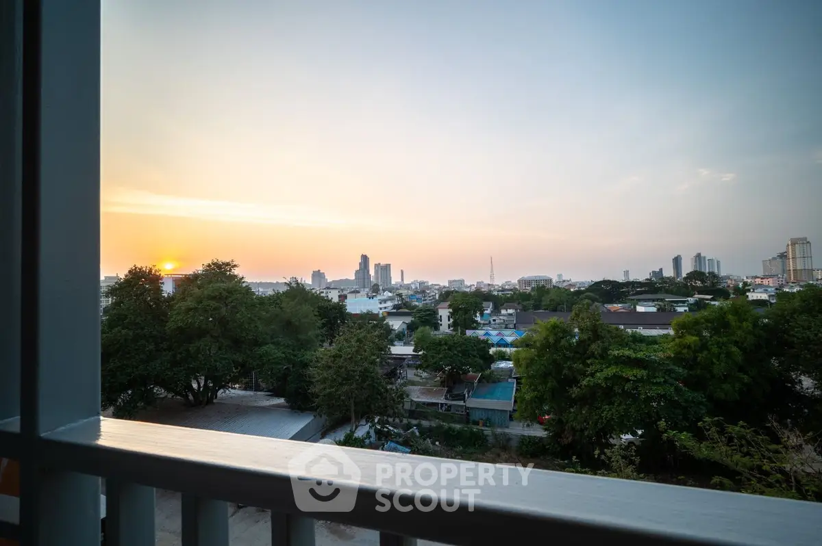 Breathtaking sunset view from a spacious balcony overlooking a serene cityscape, perfect for relaxing evenings in a prime location.