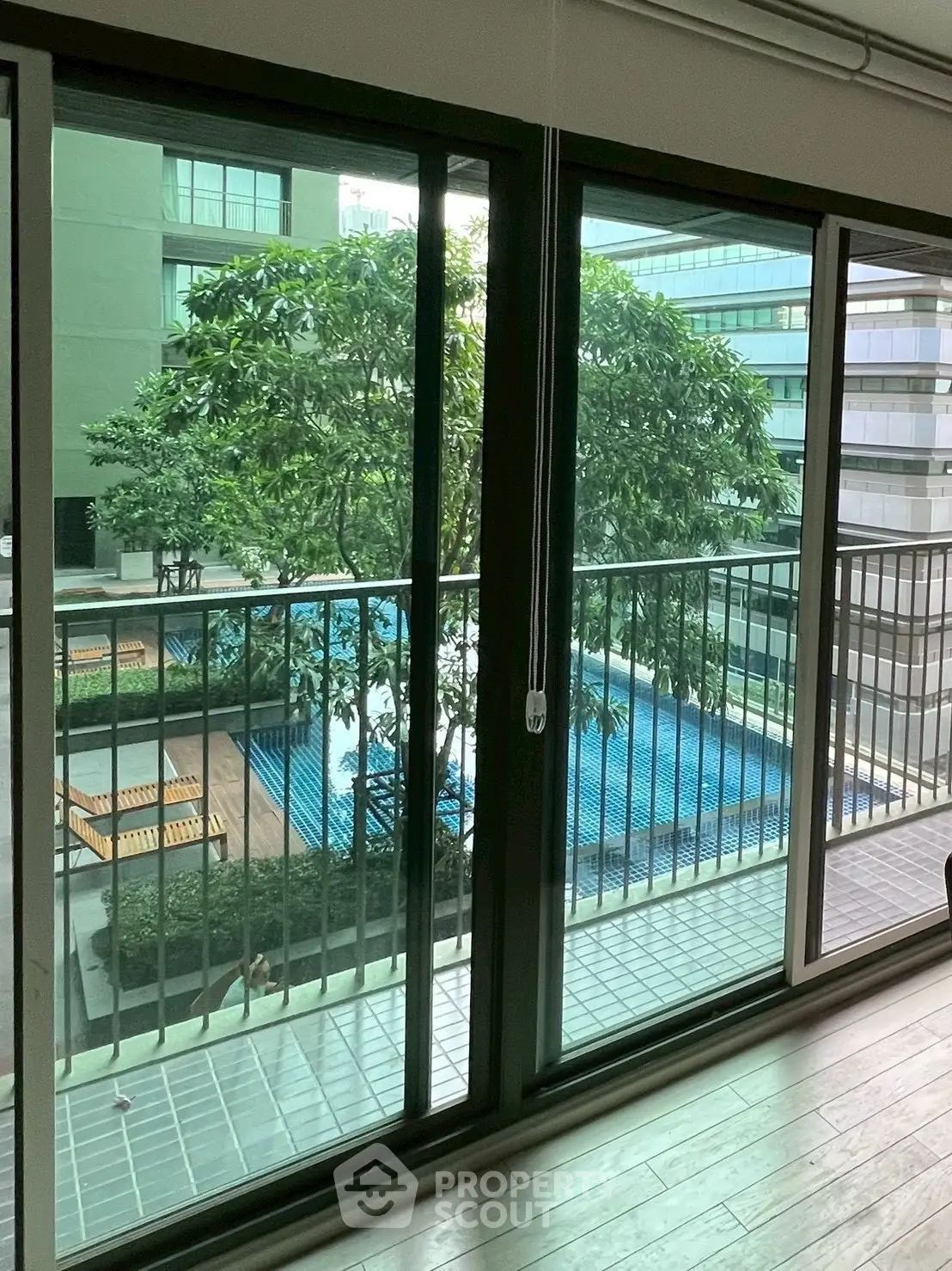 Spacious balcony with pool view in modern apartment complex