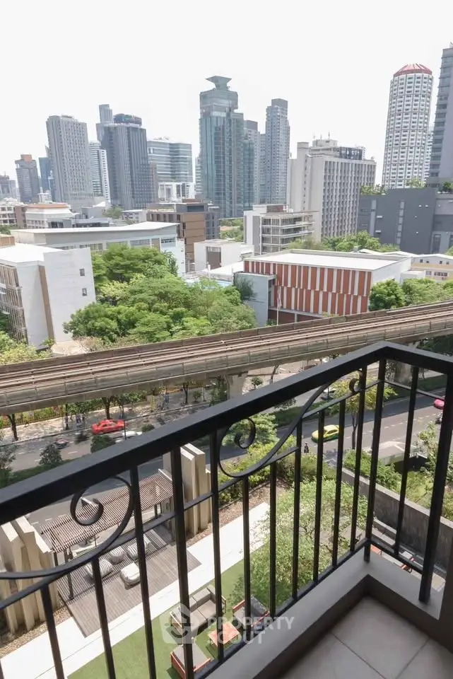 Stunning city view from a modern balcony overlooking urban skyline and lush greenery.