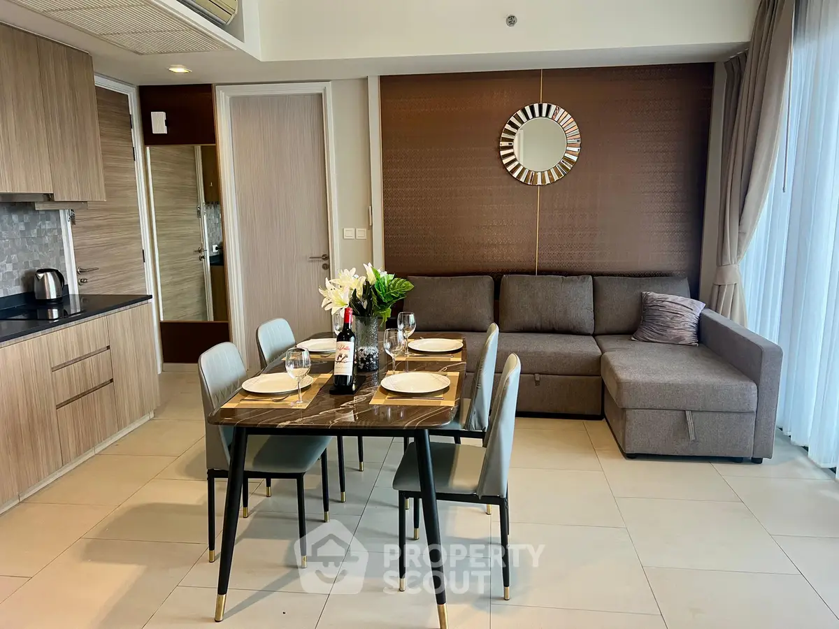 Modern living room with stylish dining area and cozy sofa in open layout apartment.