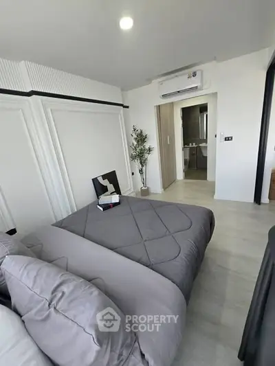 Modern bedroom with stylish decor and ensuite bathroom, featuring sleek design and cozy ambiance.