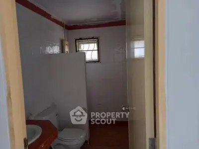 Cozy bathroom with tiled walls and small window for natural light