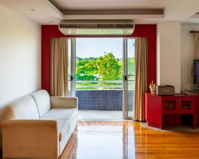 Spacious living room with balcony and scenic view, featuring modern decor and natural light.