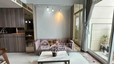 Modern living room with plush sofa, elegant decor, and large windows opening to a balcony.