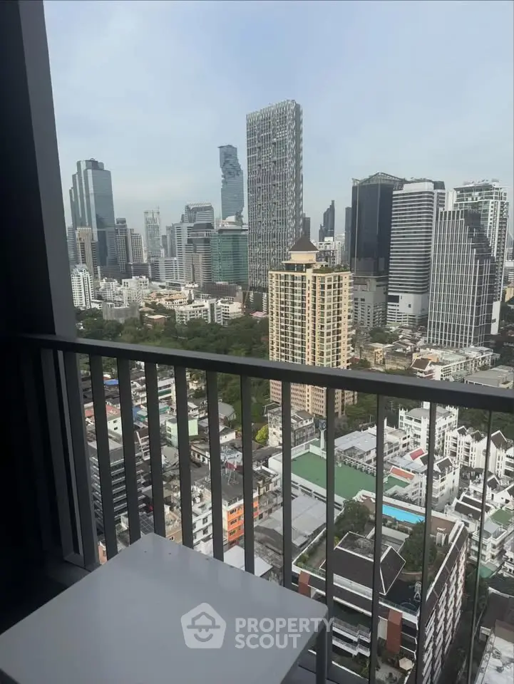 Stunning cityscape view from a high-rise balcony overlooking modern skyscrapers and urban landscape.