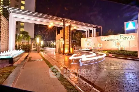 Luxurious entrance of a modern residential complex with elegant lighting and water features.