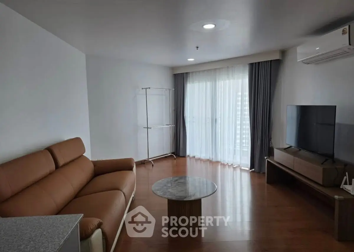 Spacious living room with modern furniture and large window for natural light.