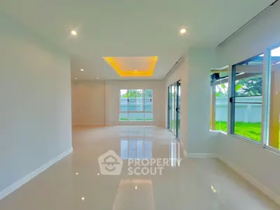 Spacious modern living room with large windows and elegant lighting