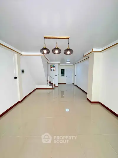 Spacious empty room with modern lighting and glossy tiled floor, ideal for customization.