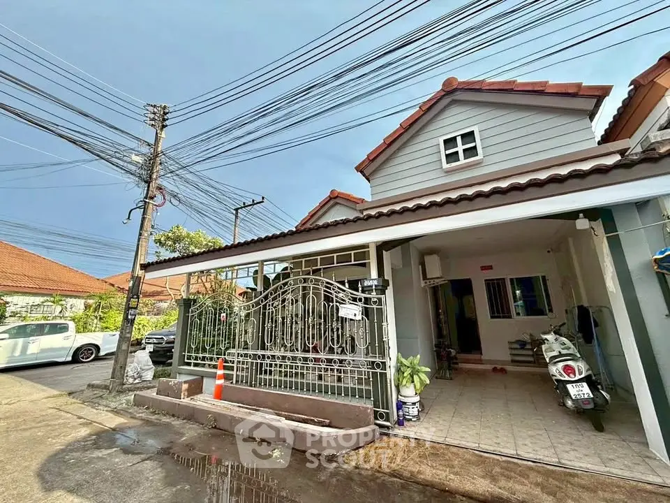 Charming suburban house with tiled roof and gated entrance, perfect for family living.