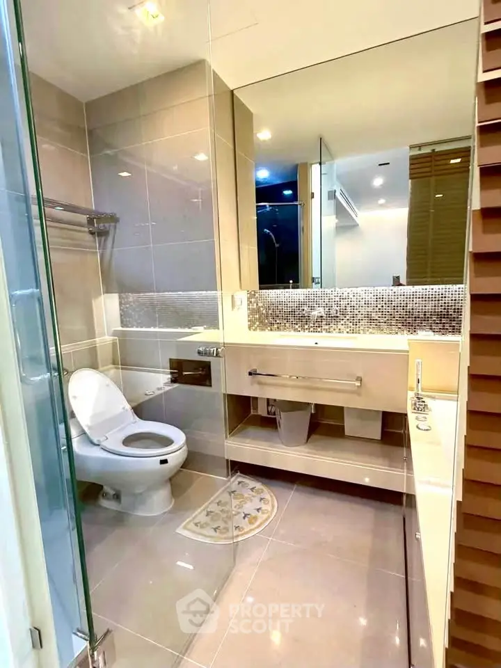Modern bathroom with sleek fixtures and elegant tile design, featuring a spacious vanity and glass shower enclosure.