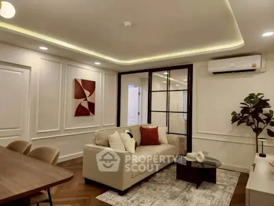 Elegant living room with modern decor, featuring a cozy sofa, stylish artwork, and ambient lighting.