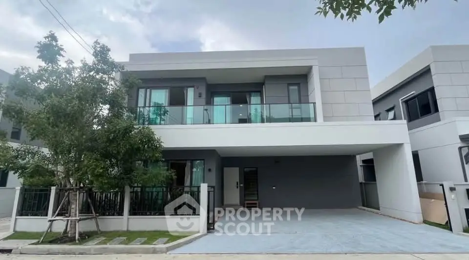 Modern two-story house with sleek design and spacious driveway in a serene neighborhood.
