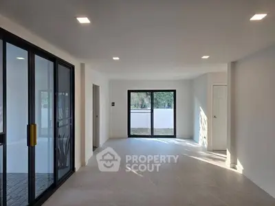 Spacious modern living room with large windows and sleek design, perfect for natural light and contemporary living.