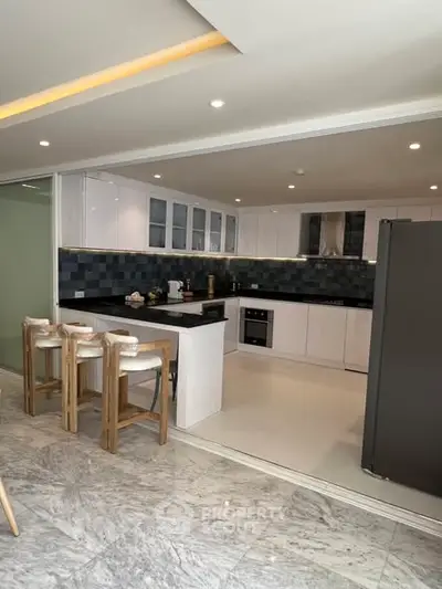 Modern open-layout kitchen with sleek cabinetry and stylish bar seating