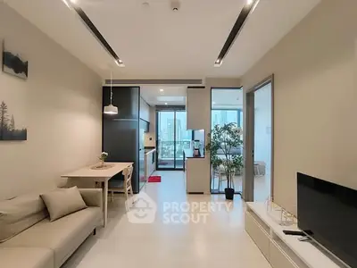 Modern living room with open kitchen and balcony view in a stylish apartment.