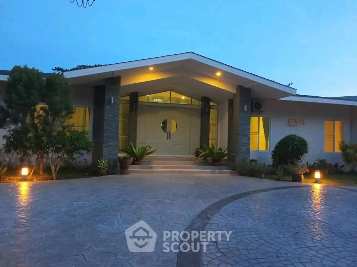 Stunning modern home entrance with elegant lighting and landscaped driveway at dusk.