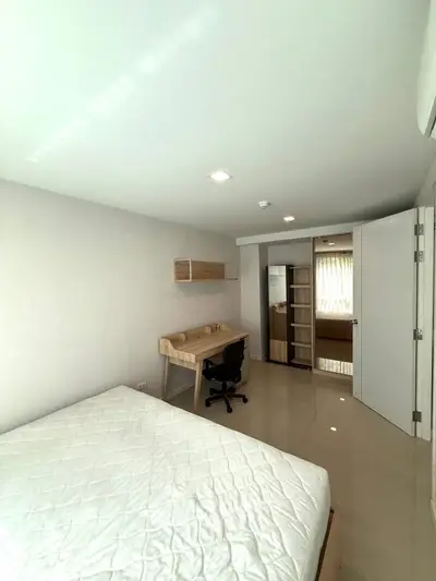 Modern bedroom with study desk and ample storage in a bright apartment