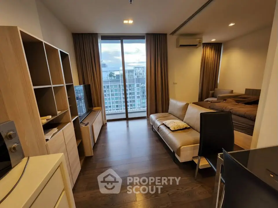 Modern living room with large windows and stylish furniture in a high-rise apartment.
