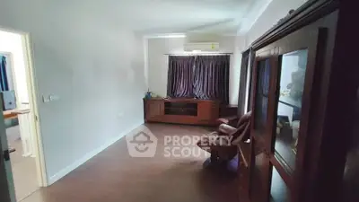Spacious living room with wooden flooring and elegant furniture, perfect for relaxation.