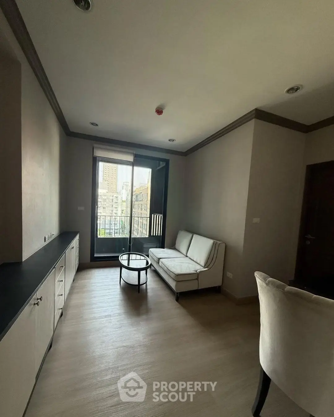 Modern living room with city view and stylish furniture in a high-rise apartment.