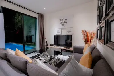Modern living room with pool view, stylish decor, and cozy seating area.