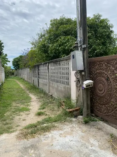 Charming property entrance with ornate gate and lush greenery, perfect for privacy and tranquility seekers.