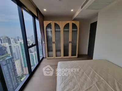 Modern bedroom with city view and stylish wardrobe in high-rise apartment