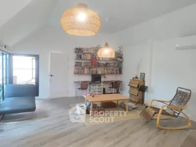 Spacious living room with modern decor and ample natural light, featuring stylish furniture and a cozy reading nook.