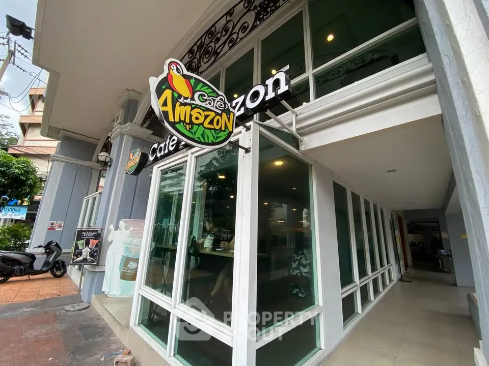 Modern cafe entrance with large glass windows and vibrant signage