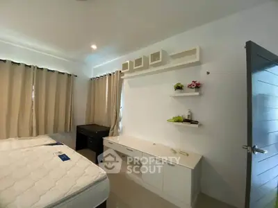 Spacious bedroom with modern decor and ample natural light, featuring a cozy bed and stylish shelving.