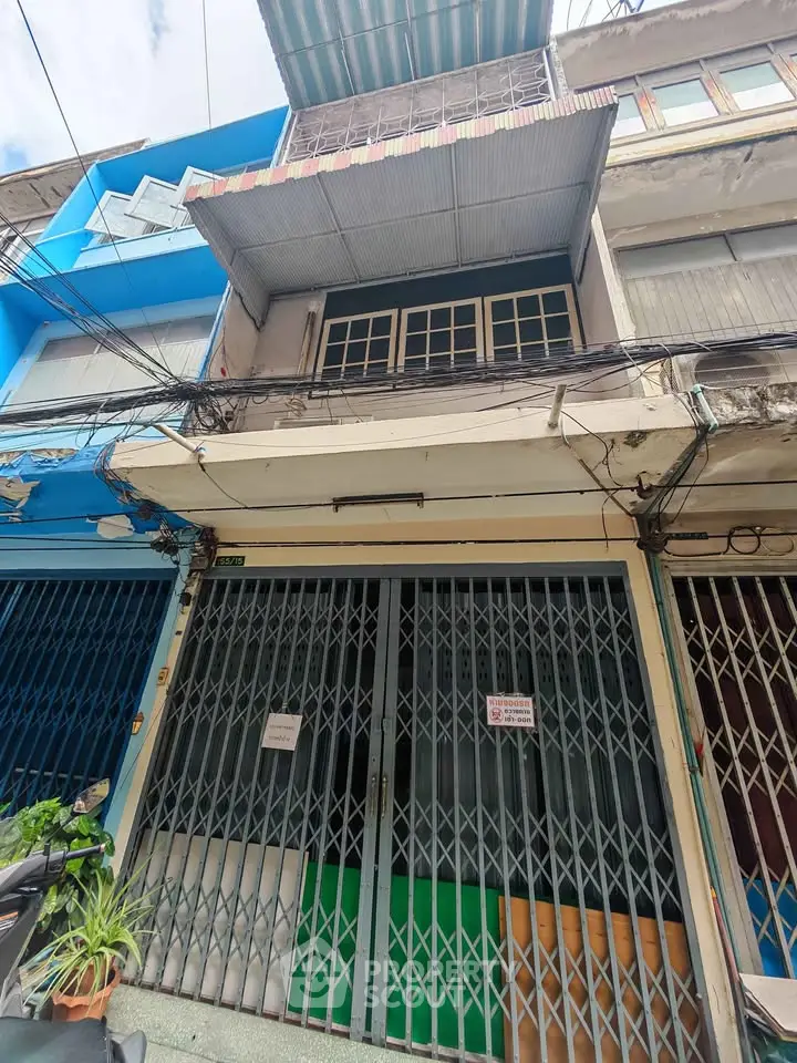 Charming urban storefront with gated entrance and colorful facade, ideal for business opportunities.
