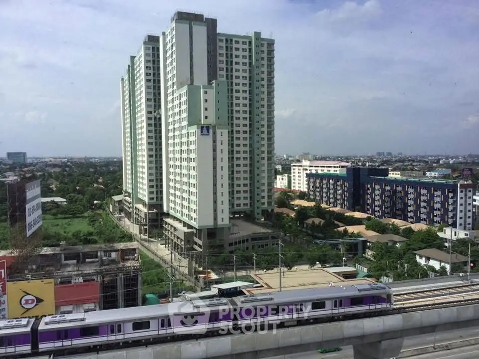 High-rise residential building with train view in urban setting, ideal for city living.