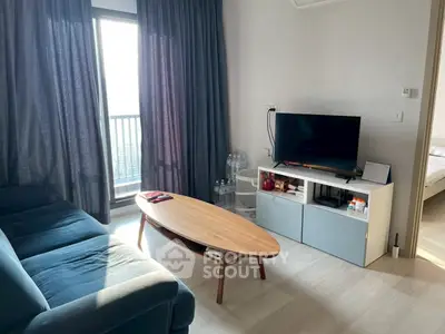 Modern living room with cozy sofa and sleek TV setup, bright natural light from balcony.