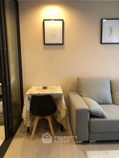 Cozy living room with modern sofa and small dining table, perfect for urban living.