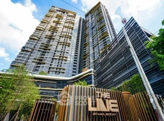 Modern high-rise condominium with sleek architecture and lush greenery at The Line Jatujak-Mochit.