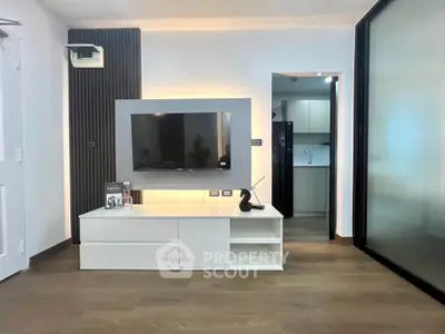 Modern living room with sleek TV unit and open kitchen view