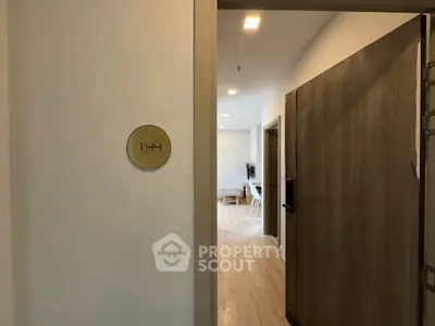 Modern apartment entrance with open door leading to a stylish interior, showcasing sleek design and inviting ambiance.