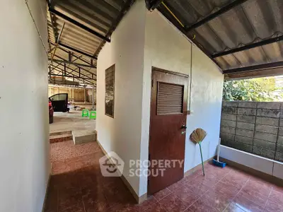 Spacious outdoor area with covered roof and storage room, ideal for versatile use.