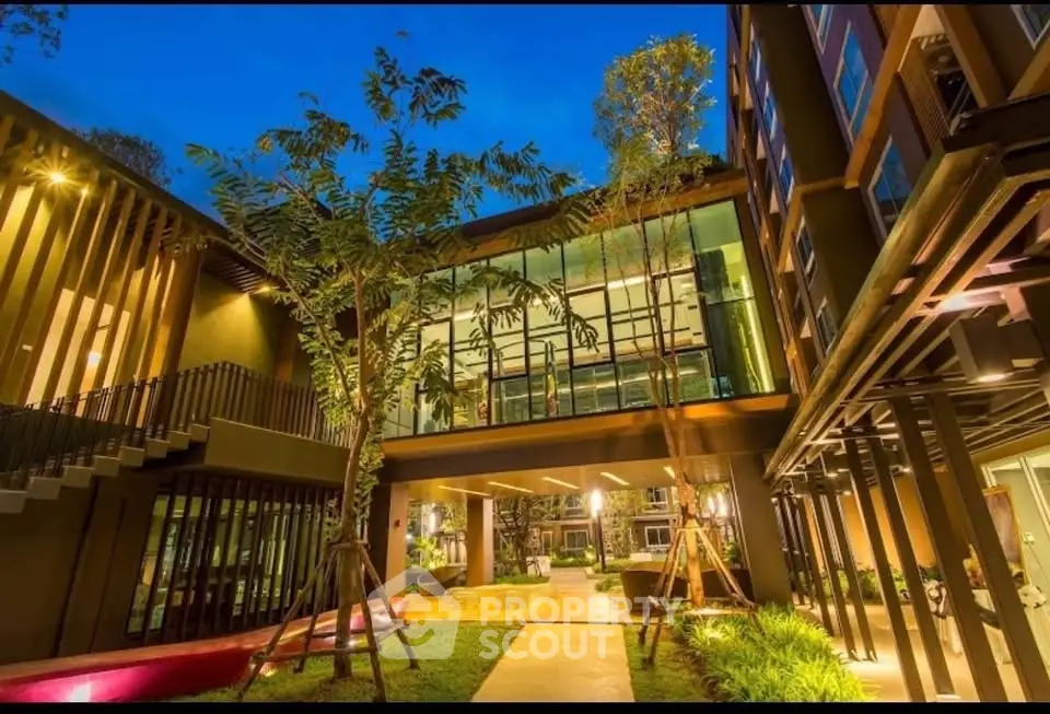 Stunning modern building exterior with lush landscaping and evening lighting.