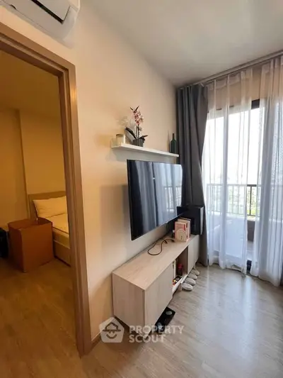 Modern living room with wall-mounted TV and balcony view